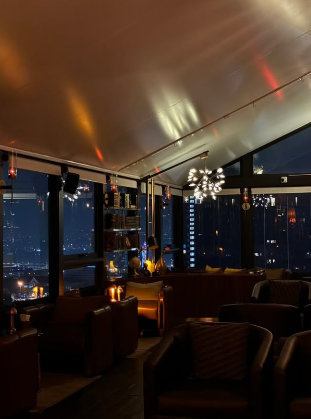 AMBER's rooftop lounge with leather armchairs and Bangkok skyline views